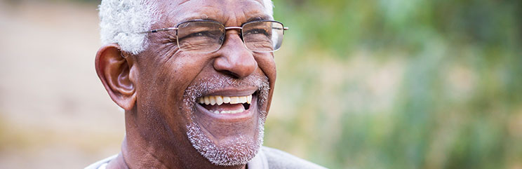 a mature man smiling outside
